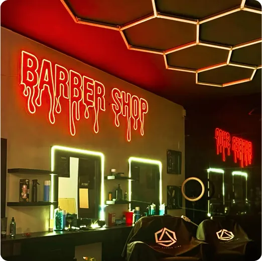Letrero neón rojo Barber Shop en la pared de una barbería